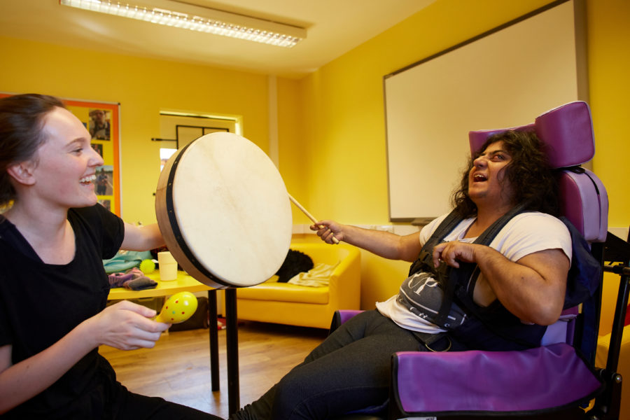 Woman at Sense College Rothwell banging a drum