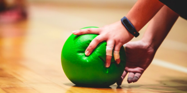 A hand holding a green ball