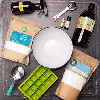 Bath bomb materials, including a silicone ice-cube tray, salts, a measuring cup and essential oils