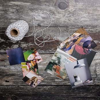 A collection of magazine cuttings and string on a wooden background