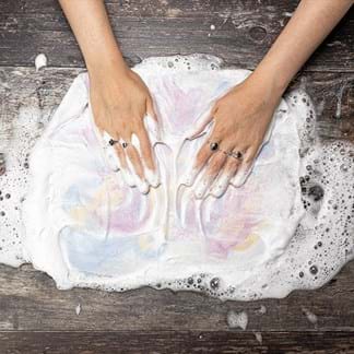Image shows the hands rubbing the felt and lots of bubbles.