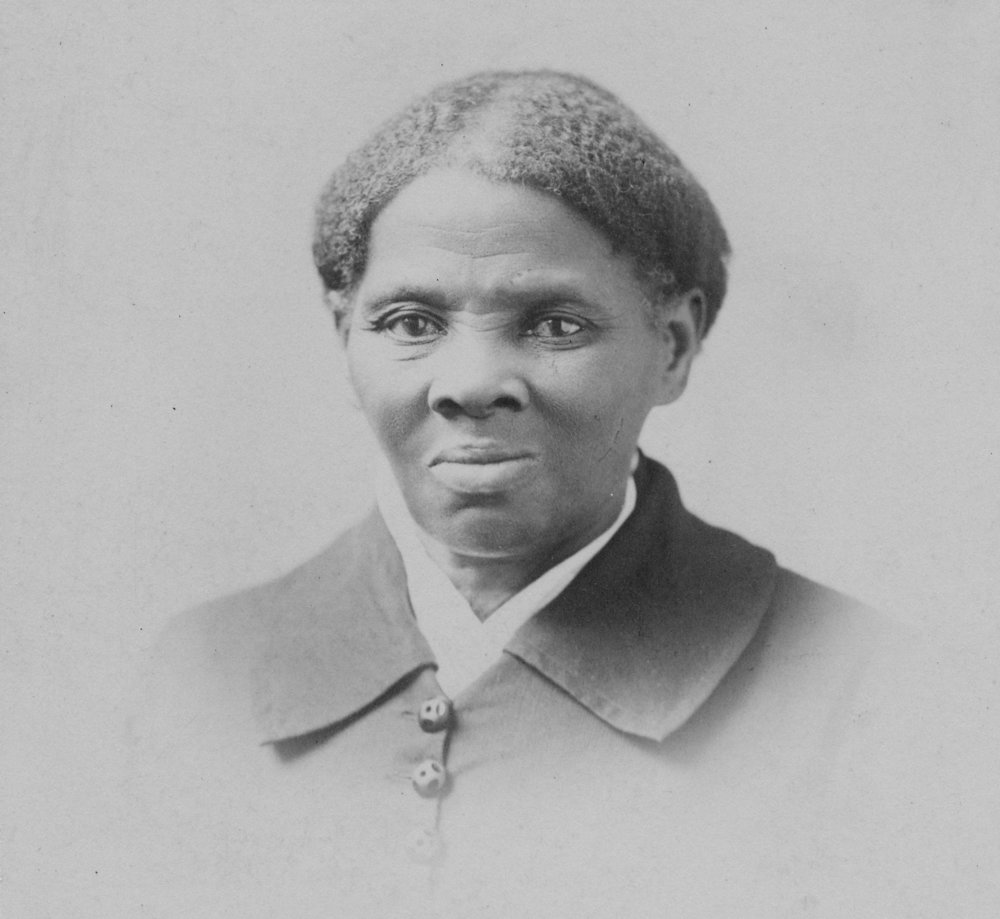 An old black and white photograph of a black woman. It's a vignette so the edges of the photo are faded in a circle.