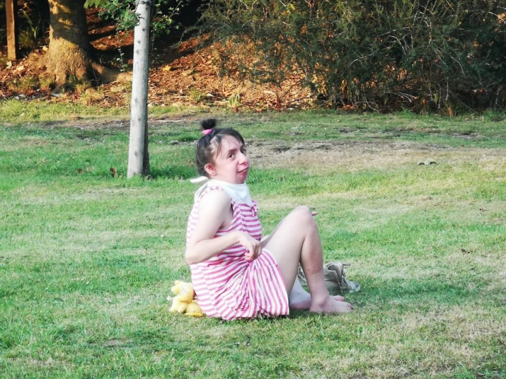 A young woman sitting on grass outside