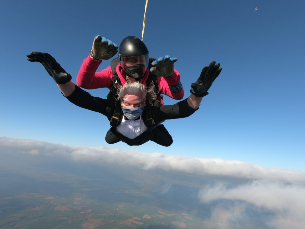 Rob Lloyd skydives strapped to another person wearing a tuxedo