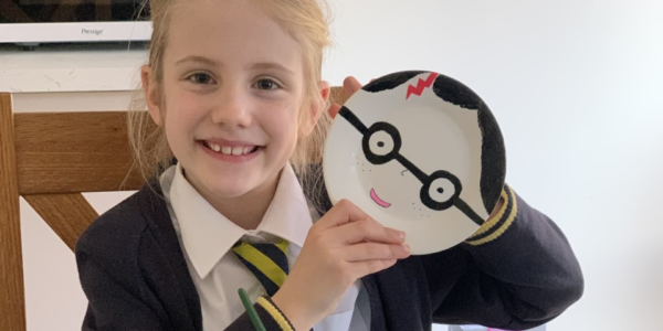 Rosie holds up her Harry Potter paper plate design to the camera