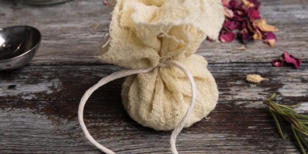 A string-wrapped bath bundle. In the background is a jar with a label that says Chamomile