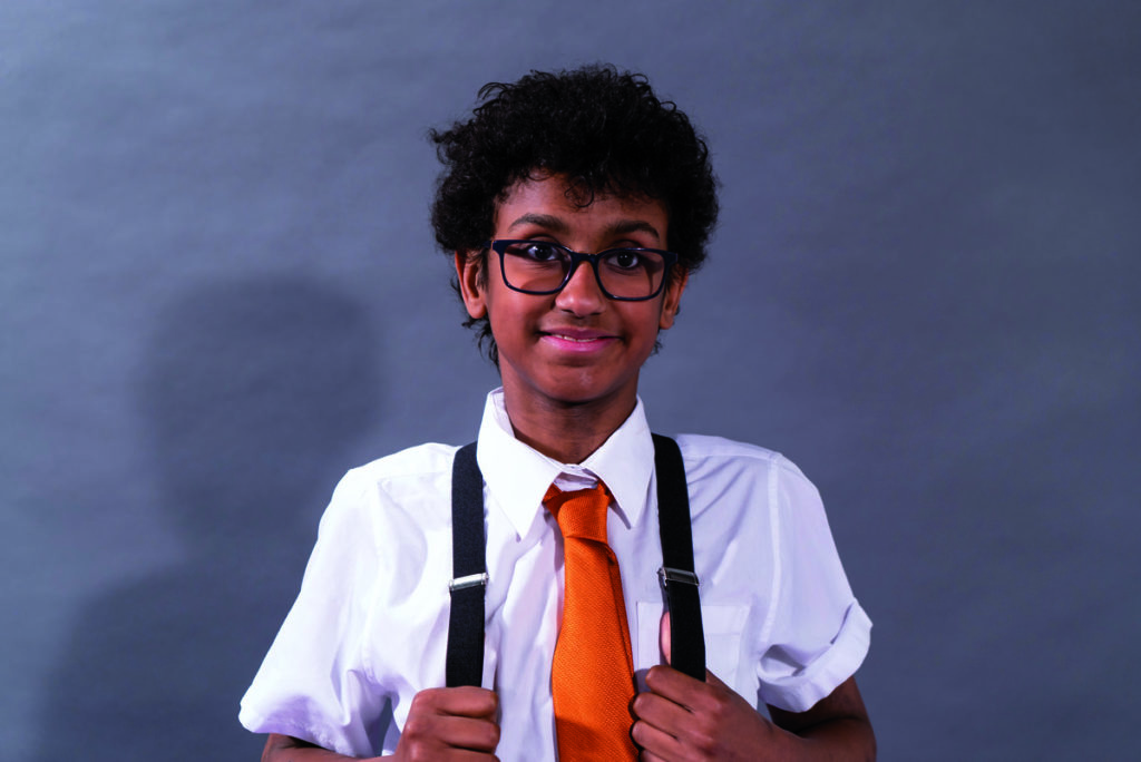 Tyrese Dibba, a mixed race 16-year-old boy wearing glasses and a bright orange tie.