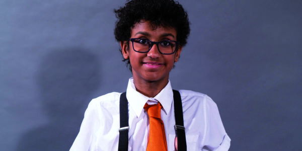 Tyrese Dibba, a mixed race 16-year-old boy wearing glasses and a bright orange tie.