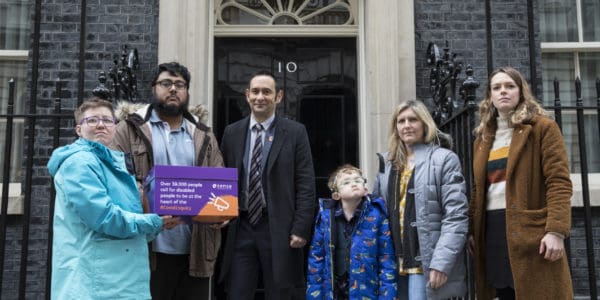 6 people stand in front of 10 downing st with a box of petitions