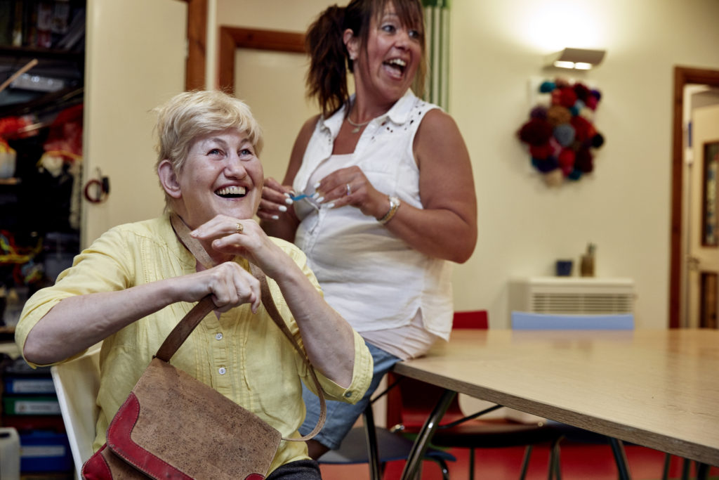 Lin Wallace, a Sense Living tenant, and a support worker laughing together.