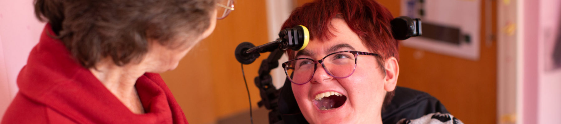 Sally, a white woman with short hair, smiling while communicating with her intervenor.