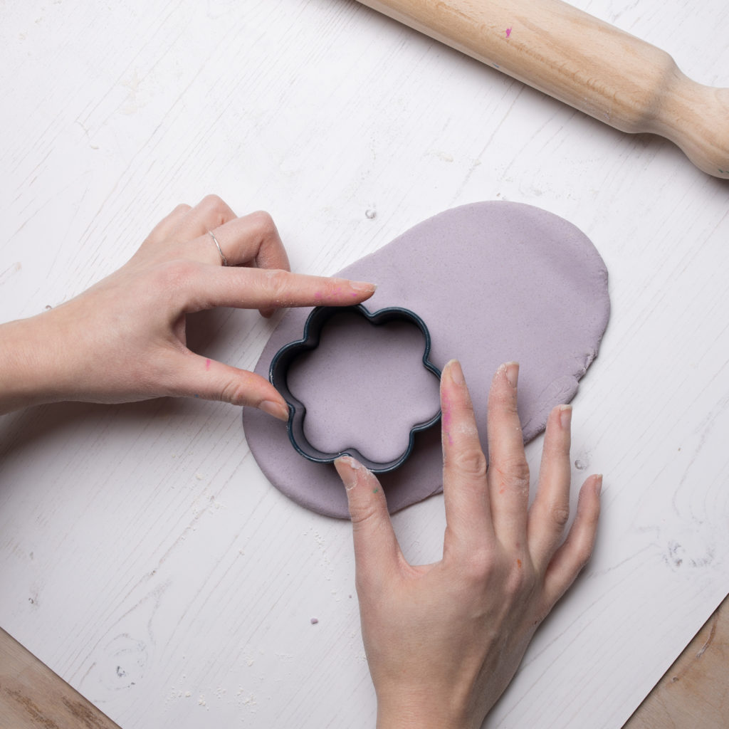 Making a shape in the natural scented purple playdough with a cookie cutter