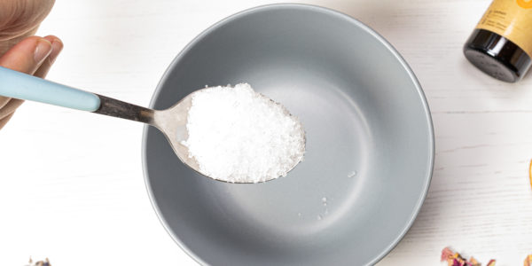 A spoon of salt being added to the bowl