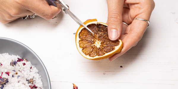 Using scissors to snip up a dried slice of orange