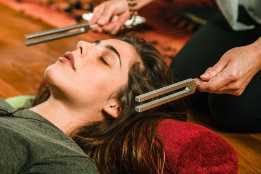 Person lay on the floor during a tuning fork session