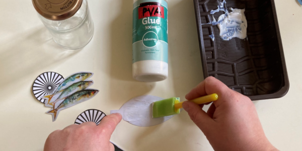 Applying glue to the back of a leaf with brush