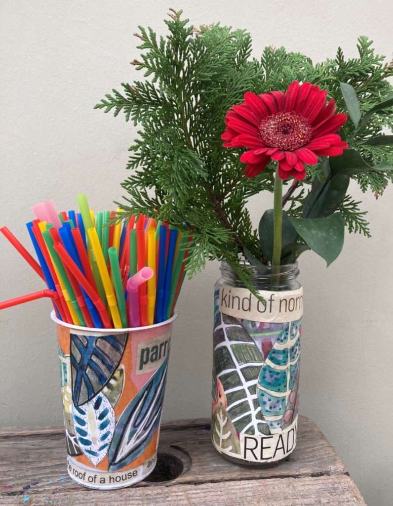2 finished collage vases, the left one is filled with colourful straws and the one on the right has some greenery and a red flower in it.