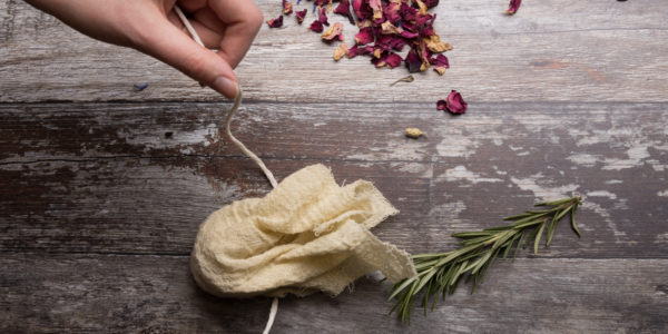 Wrapping a piece of string around a little linen package of scented salts