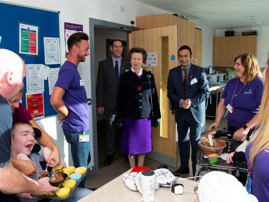 Princess Anne at a Sense family centre surrounded by Sense staff and residents.