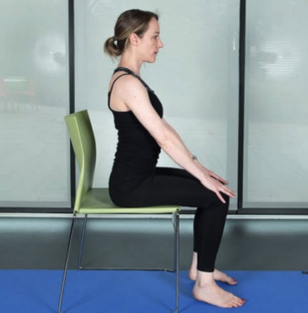 woman sitting on a chair with hands on knees