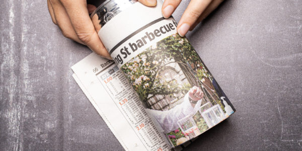 Image shows the can rolled up in the newspaper