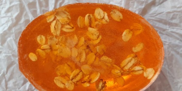 A piece of bright orange soap with oats