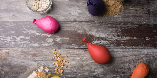 Finished textured balloon surrounded by spilled jars of grains on a wooden background