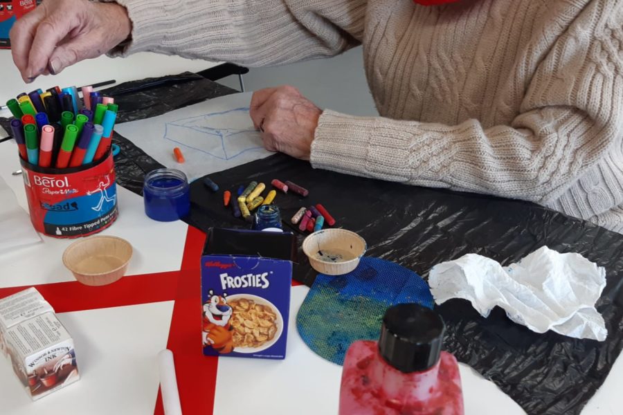 Adult taking part in art session using felt tip pens and crayons.