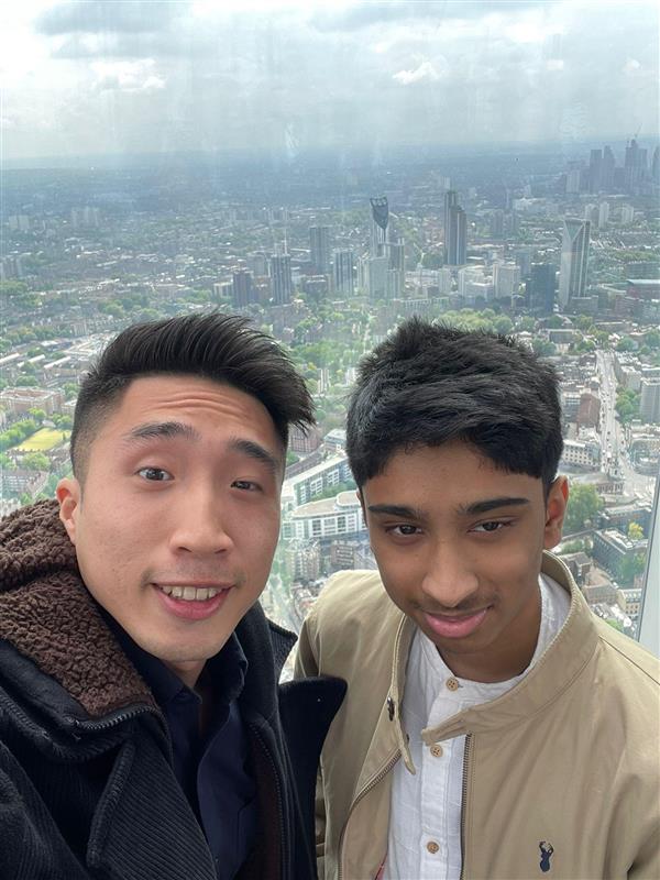 A man and a boy stand in front of a view of London from the top of the Shard
