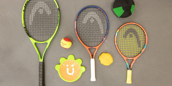 a group of tennis rackets and balls lying on the floor