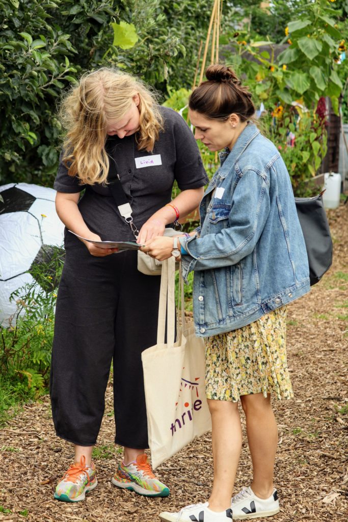 Two women are looking at a map in a garden