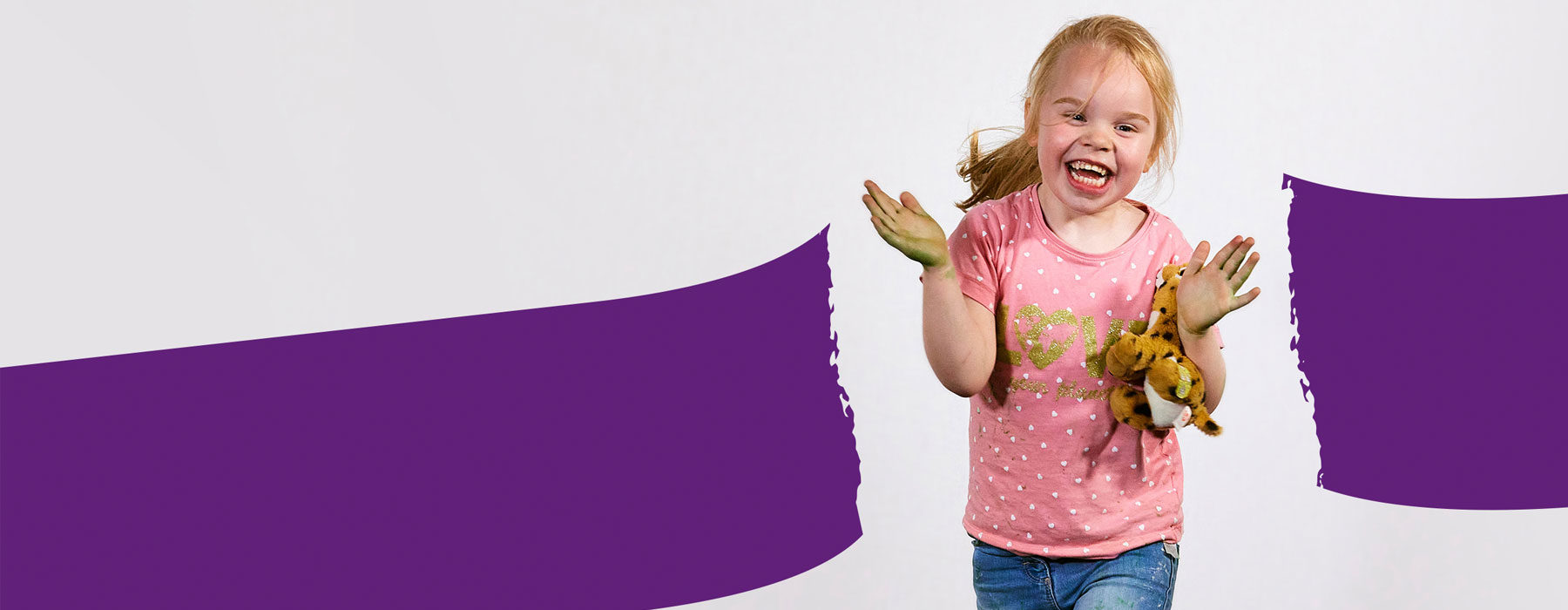 Smiling little girl breaks through a purple barrier