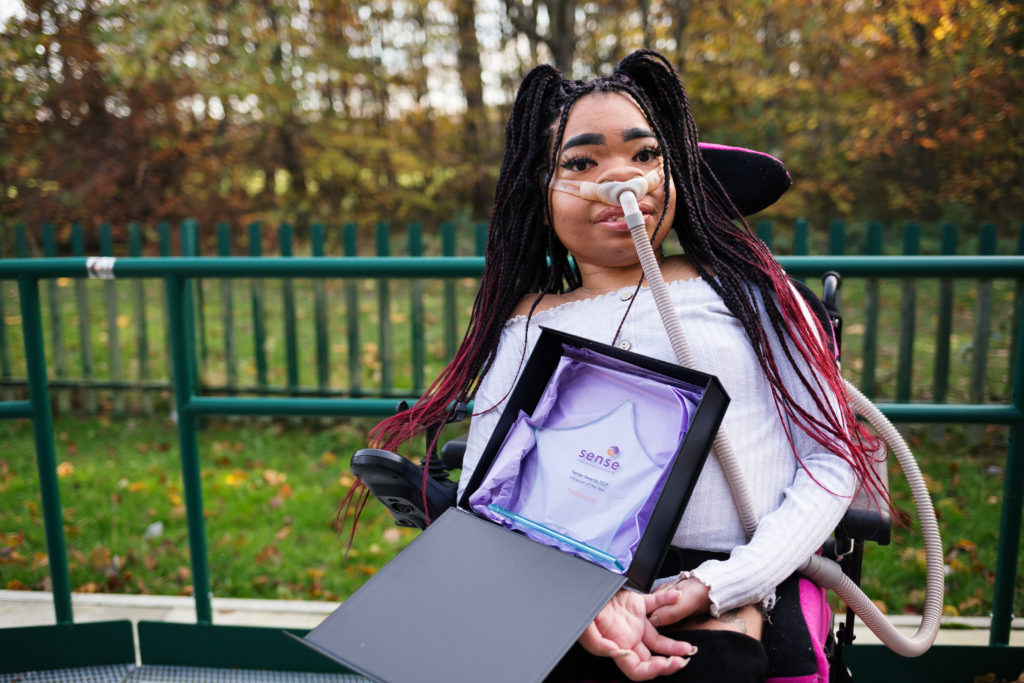 Shelby Lynch, Winner of the Influencer of the Year Award 2021. Shelby is a young woman with long black and pink braids, in a wheelchair.
