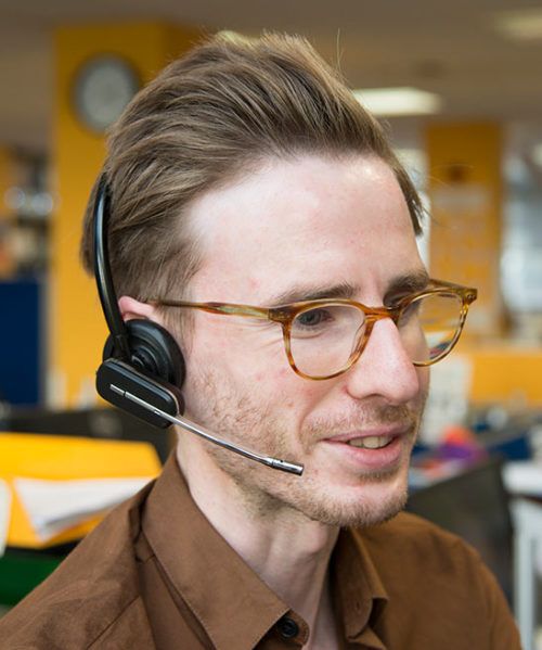 A man wearing a headset and glasses looking suitably