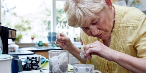 Lin, a woman with short grey hair, making a cup of tea in her supported living home in Exeter.