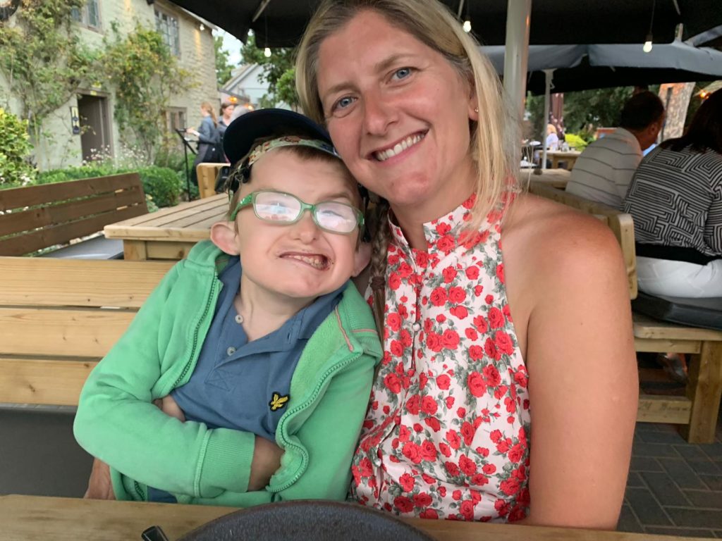 Hugo with his mum sitting in a restaurant