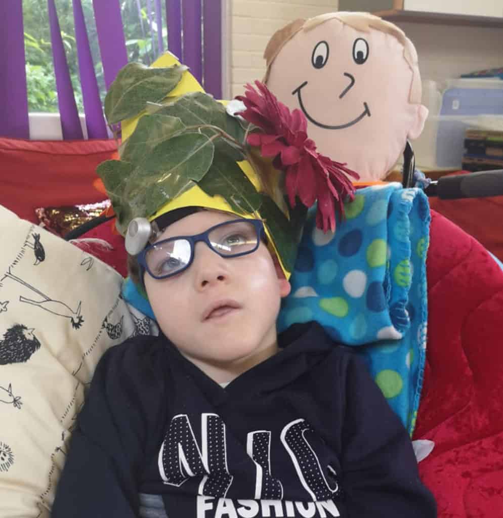 Logan sitting in a chair wearing a home made hat