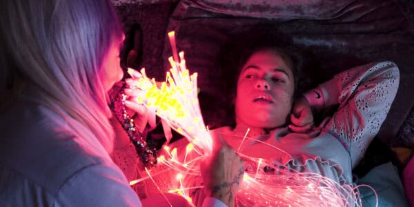 Rosey looks at some colourful lights held up by her mum, Yvette.