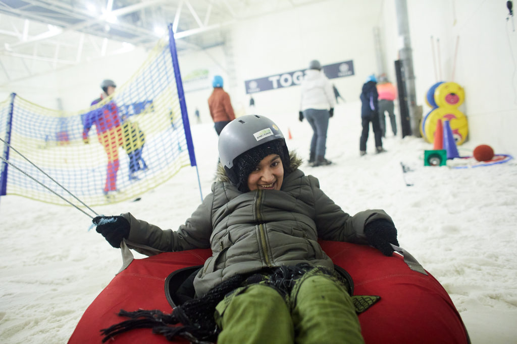 A young person smiles while trying sledging at Snozone in Castleford.