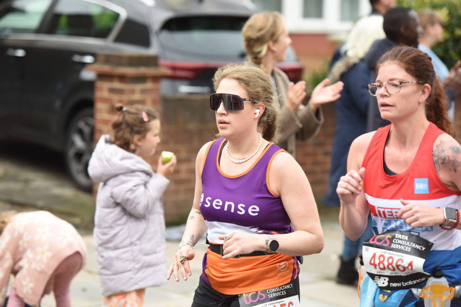 A woman running and wearing sunglasses