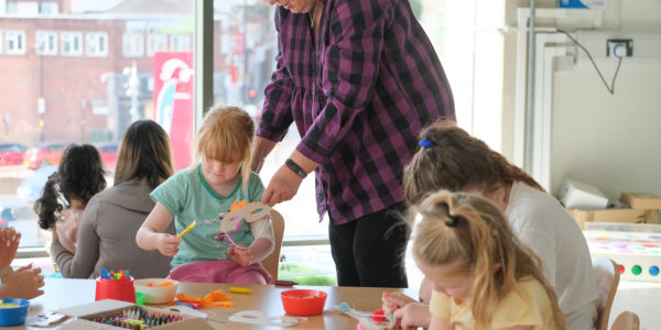 A group of young children sitting around a table taking part in a craft activity.