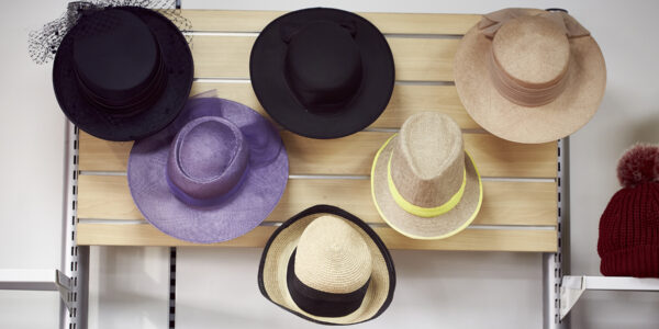 A selection of hats in different styles hanging on the wall.