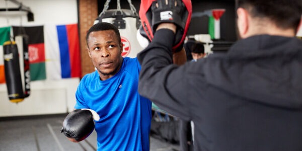 A young man in boxing gloves training in the gym.