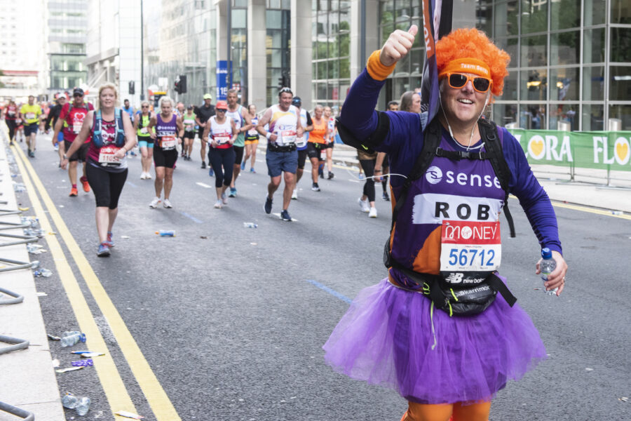 Rob Lloyd, in a purple tutu and orange wig, running a marathon for Sense.