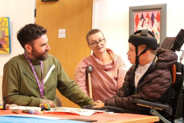 Three people chatting over artwork