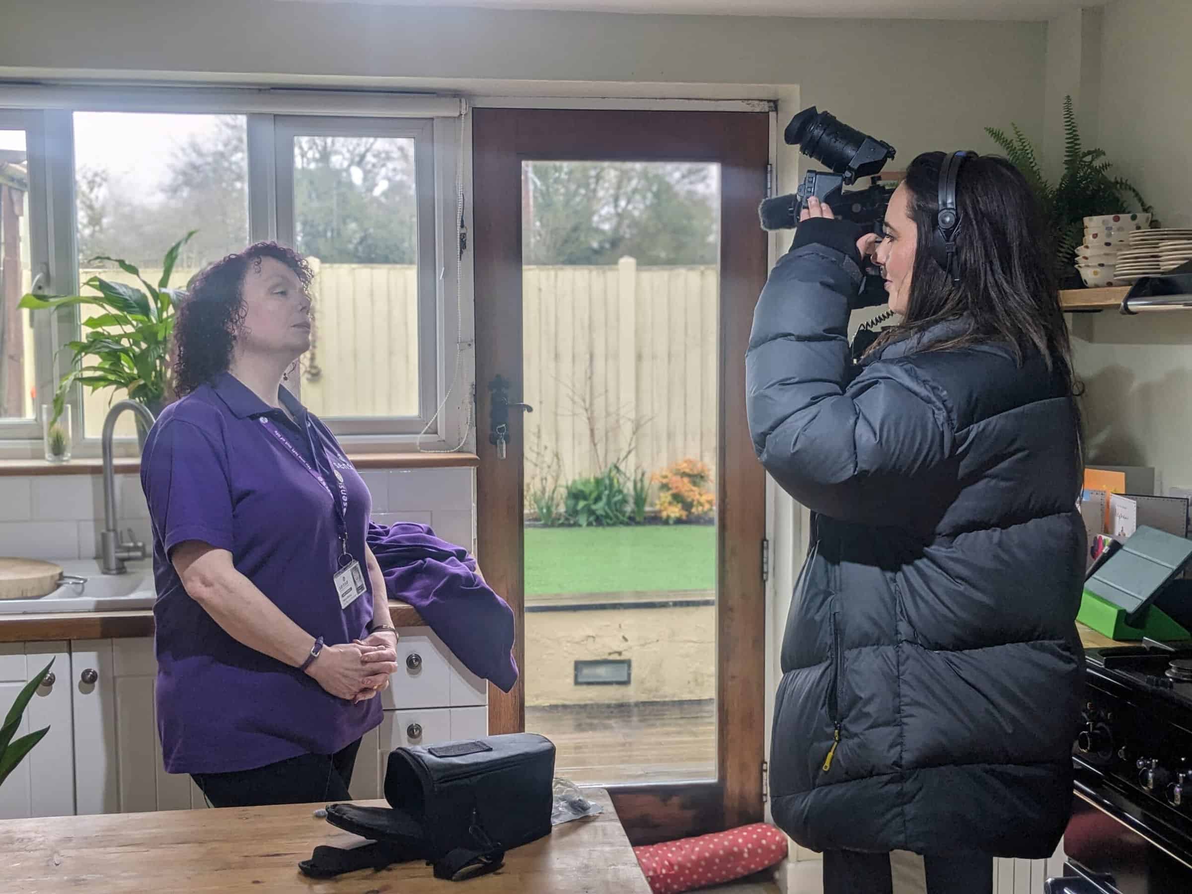 A woman in a Sense t-short talks into a camera