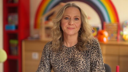 Kellie Bright sits in front of a children's play area