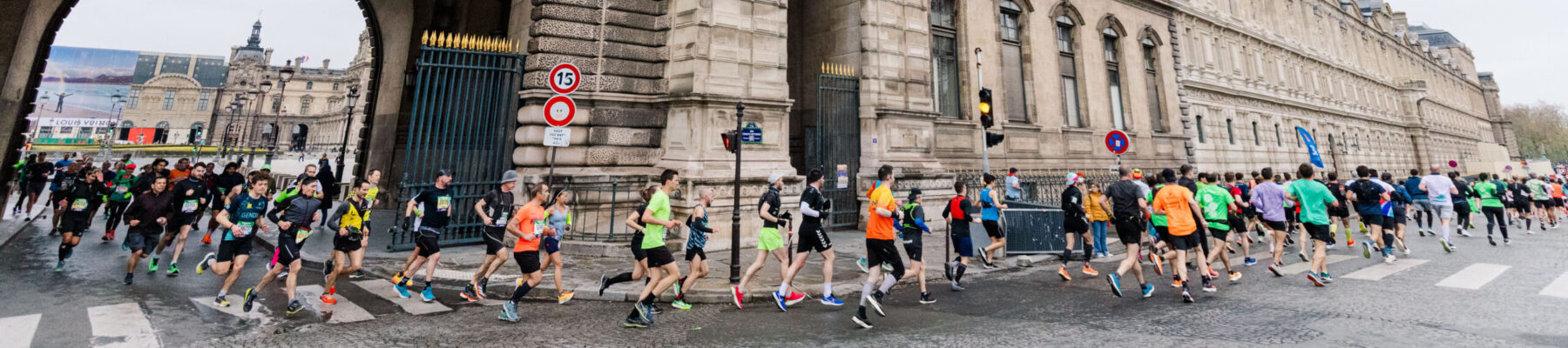 Marathon runners, running under and arch in Paris