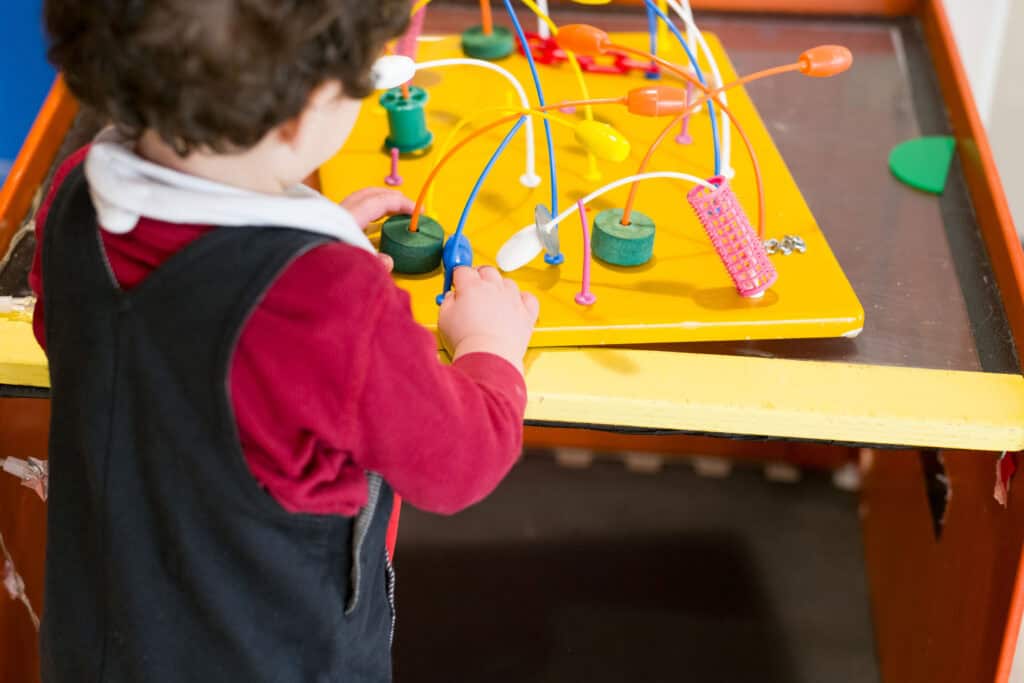 A young child playing with an abacus.