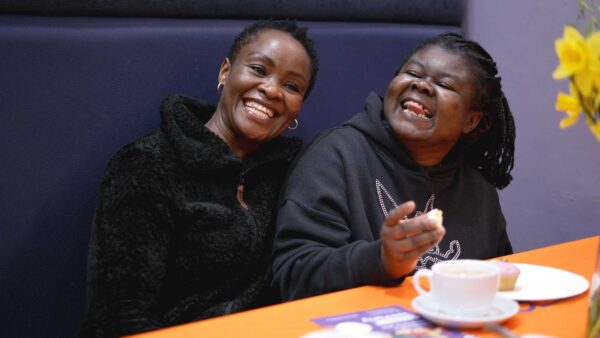 Two women sitting at a table with a cup of tea